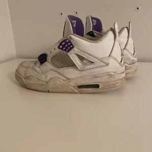 Nike Air Jordan 4 vit/lila strl 42 - Säljer ett par Nike Air Jordan 4 i vitt med lila detaljer och meshpaneler. Skorna har klassisk Jordan-logga bak och lila insida. Har tagit bort snöret men kan sätta ditt igen.  Dom är lite slitna men det funkar endå 