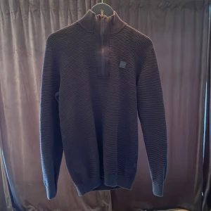 Svart half zip tröja Solid - Snygg svart tröja från !Solid i storlek M. Tröjan har en hög krage med half zip-dragkedja och diskret logopatch på bröstet. Långa ärmar och ribbade muddar.