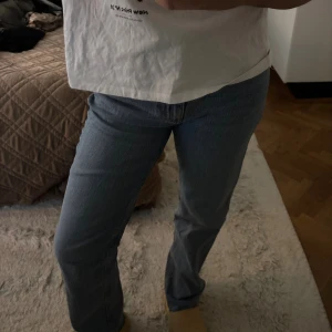 Snygga blå jeans straight fit - Säljer ett par klassiska jeans i ljusblå tvätt med straight fit. Byxorna har hög midja, fem fickor och knappgylf. Perfekt passform och tidlös look, tillverkade i robust denim. Snygga att styla med sneakers eller boots.