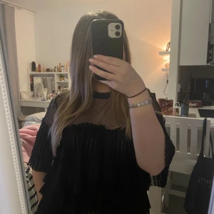 Svart transparent blus med volanger - passar även storlek S