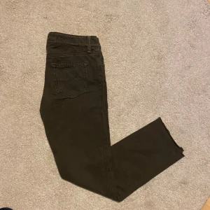 Mörkgrå jeans från Jacob Cohen - Snygga mörkgrå jeans från Jacob Cohen med klassisk femficksdesign och diskret broderad J på myntfickan. Byxorna har normal passform, raka ben och är tillverkade i mjuk bomull med lite stretch för extra komfort. Perfekt för dig som gillar stilrena och tidlösa jeans.