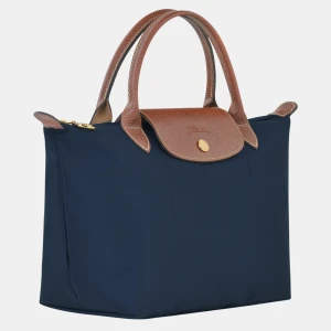 Mörkblå Longchamp väska! - Superfin mörkblå väska från Longchamp! Köpt på Plick så den är använd fåtal gånger, se små vita defekter på bild 4, men det är inget man märker eller tänker på! Hör av dig vid frågor eller fler bilder💗pris kan diskuteras!