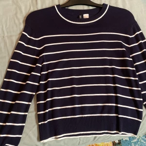 Marinblå randig tröja från H&M Divided - Snygg marinblå tröja från H&M Divided i storlek XS. Tröjan har vita horisontella ränder och rund hals med vit kant. Långärmad och i mjukt bomullsmaterial, perfekt för dig som gillar klassisk och enkel stil.