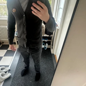 Mörkgrå kofta Abercrombie & Fitch M - Snygg mörkgrå kofta från Abercrombie & Fitch i storlek M. Stickad i mjukt material med broderad logga på bröstet, två fickor framtill och knappar hela vägen. Perfekt för lager-på-lager och chill stil. Tyvärr är tröjan nopprig men går att få bort med noppermaskin 