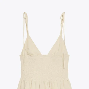 Beige topp från zara - Supersöt beige topp från Zara med smockad midja och tunna axelband som knyts upptill.  Toppen har v-ringad urringning och är tillverkad i ett lätt, luftigt material. Helt ny prislapp finns original pris 380kr 