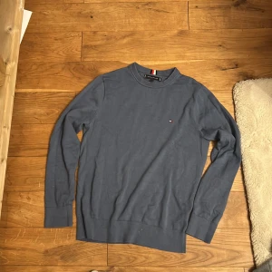 Blå tröja från Tommy Hilfiger XS - Snygg blå tröja från Tommy Hilfiger i storlek XS. Klassisk rund halsringning med ribbade muddar och diskret broderad logga på bröstet. Perfekt basic med stilren vibe och mjukt material.