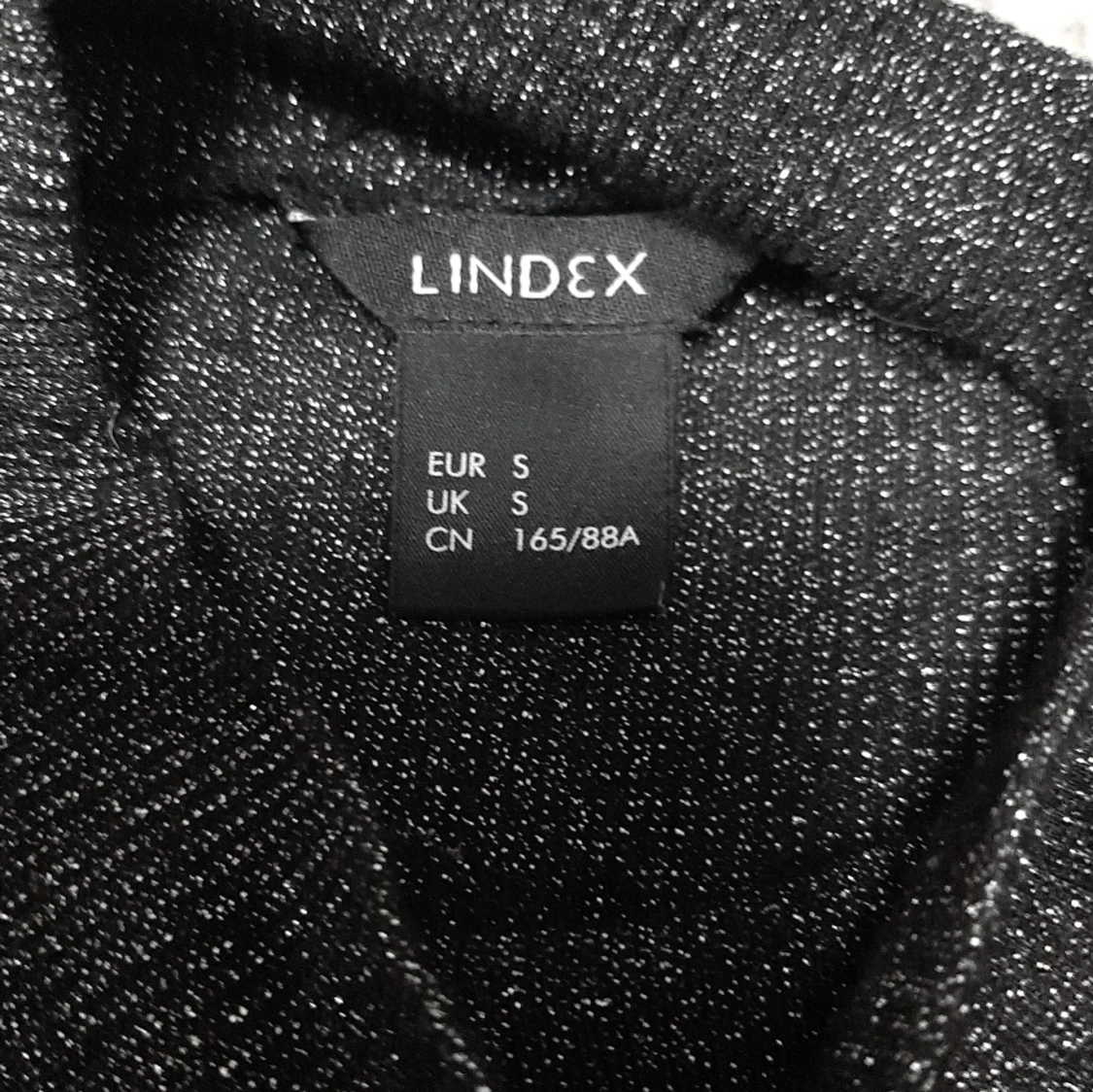 Glittrig svart polotopp från Lindex - 1