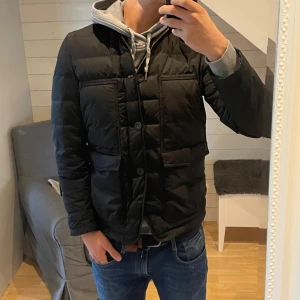 J. Lindeberg jacka - Säljer denna riktigt snygga vinterjacka från          J. Lindeberg! Jackan har en dragkedja och 3 knappar och är ganska tjockt fodrad vilket gör den perfekt nu till hösten och vintern! Den är i mycket bra skick och har inga hål eller lagningar, den är i storlek M, den är 67 cm lång och 51 cm bred under armhålorna, jag på bilderna är 184 cm lång och väger 82 kg, mer bilder finns vid intresse, tveka inte att höra av dig vid funderingar🙌