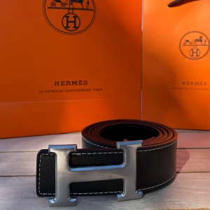 H Bälte Svart - Säljer ett svart bälte med ett silvrigt snyggt ”H” spänne. Bältet har en längd på 105 cm (storlek 42) och är Inte använt en enda gång, tveka inte att fråga! 💯👌 