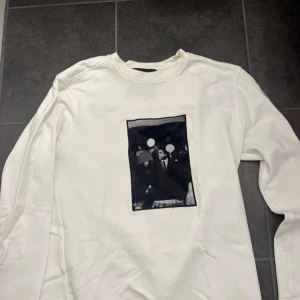 Limitato tröja - Vit långärmad sweatshirt från Muhammad Ali Limited med svartvit grafiskt tryck på bröstet. Tröjan har rund halsringning och en clean look som passar till jeans eller cargobyxor. Mjuk bomullskänsla och relaxed fit. Använd få antal gånger