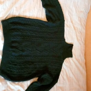 Mörkblå polotröja Leo Gemelli - Säljer en mörkblå polotröja från Leo Gemelli med klassiskt flätstickat mönster. Tröjan har hög polokrage, lång ärm och är stickad i ett tjockare material som passar perfekt när det är kallt ute.