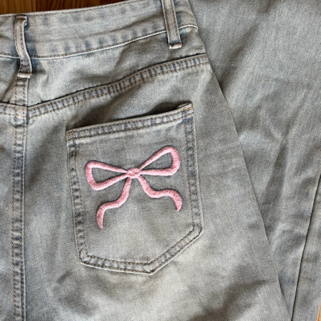 Ljusblåa jeans med rosa rosetter