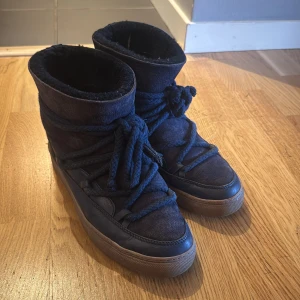 Mörkblå Inuikii boots med snörning - Säljer mina mörkblå inuikiis, färgen är eftertraktad och unik och svår att få tag på. Dom är tillverkade i mocka och skinn med en platt sula i gummi. Först till kvarn🥰