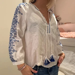 Zara blus 🐠 - Säljer en vit blus med blåa mönster vid armarna. Tröja är lite insydd vid sidan, men inget som märks. 