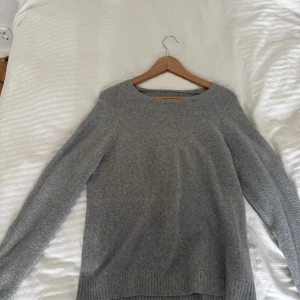 Grå stickad tröja i kashmir - Mysig grå stickad tröja med rund halsringning och långa ärmar. Perfekt nu till hösten
