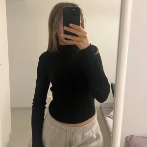 Svart polotröja med öppen rygg och knyt - Säljer fin svart tröja med öppen rygg från H&M. Smått polo modell vid halsen. Köpt på second hand men har själv knappt använt den, i gott skick. Tjockt material och inte genomskinlig. Knyte där bak 💕