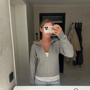 Grå hoodie med dragkedja och huva - Säljer en ljusgrå hoodie med dragkedja och huva från Gina Tricot. Storlek M ingen prislapp men aldrig använd 