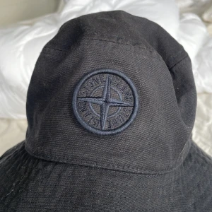 Svart bucket hat från Stone Island - Säljer en svart bucket hat från Stone island som är väldigt skön och passar till allt. Köpt på NK för 1000kr 