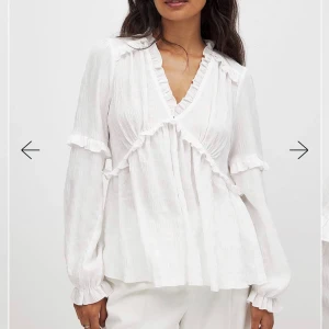 Vit volangblus från NA-KD - Superfin vit blus från NA-KD med v-ringning, volangdetaljer och långa ärmar med resår vid ärmslut. Blusen har en luftig och lätt struktur i ett tunt tyg. Använt fåtal gånger så mycket bra skick.🤍Ordinatiepris: 399kr