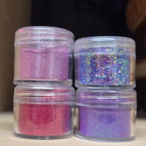 4 pack glitter till naglar  - Säljer fyra burkar med löst glitter i lila till naglar. Kommer i små genomskinliga plastburkar. Burkarna kan ha repor pga att ha legat bland andra produkter och märkta med något nummer, men det är inga problem med produkten. 