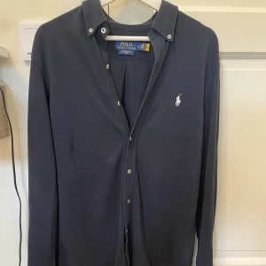 Mörkblå skjorta från Polo Ralph Lauren - Snygg mörkblå skjorta från Polo Ralph Lauren i featherweight mesh. Skjortan är i gott skick och är något slim i passformen. Köparen står för frakten📬Tveka inte att höra va dig om du har några frågor!🌟