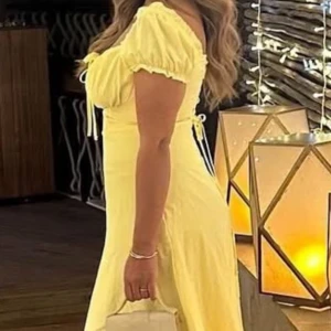 Ljusgul långklänning med puffärm - Säljer en superfin ljusgul långklänning med puffiga kortärmar och snörning vid bysten. Klänningen har en feminin siluett med markerad midja och mjukt fallande kjol. Perfekt för sommarkvällar och har en romantisk vibe. Materialet känns lätt och luftigt.