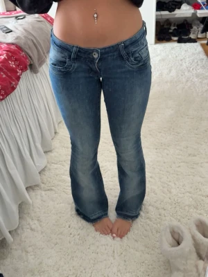Blå bootcut jeans Gina Tricot S - Säljer ett par blå bootcut jeans från Gina Tricot i storlek S. Jeansen har låg midja, klassiska fem fickor och snygg tvätt med lätt slitningar. Materialet är jeans och passformen är normal med lite utsvängda ben. Aldig använda
