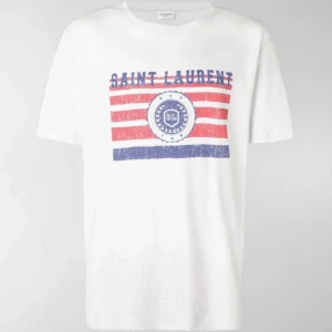 Saint Laurent T-Shirt - Sjukt snygg och ovanlig YSL tischa i riktigt fint skick! Storlek M och självklart äkta. Är i princip omöjlig att hitta (särskilt till detta pris också) så passa på! Inget annat ingår endast t shirten. Alla slitningar är en del av designen!