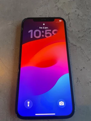 iPhone 12 64GB Blå - Säljer en blå iPhone 12. Skärmen har sprickor i övre vänstra hörnet och ramen är sliten. Batterihälsan är 77%. Telefonen fungerar i övrigt bra och är olåst.