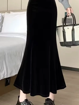 Svart långkjol i sammet - Säljer en svart långkjol i mjuk sammet med lätt utsvängd siluett. Kjolen har en hög midja och följsam passform som ger en elegant look. Perfekt att styla med en croppad topp eller stickad tröja för en trendig vibe.