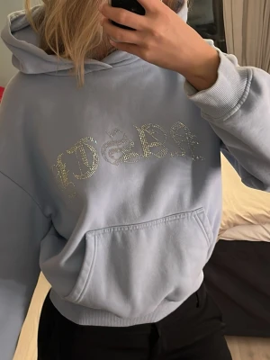 Ljusblå hoddie med rhinestones  - En ljus blå cropped hoddie med rhinestones.