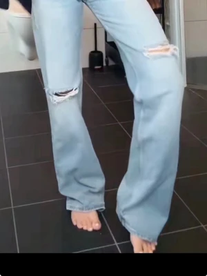 Söker!!!!!Wide leg jeans med slitningar ljusblå  - SÖKER!!!! ett par ljusblå wide leg jeans från TRF med slitningar över knäna och mellanblå tvätt. Jeansen har mellanmidja STRL 40/42