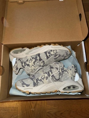 Nike NOCTA Air Terra Hot Step sneakers - Säljer ett par Nike NOCTA Air Terra Hot Step sneakers i beige och grått som jag fick i min nocta mysterybox. Skorna har synlig Air-dämpning, gummisula i ljusbrun och mesh-överdel för extra komfort. NOCTA-logga på innersulan och detaljer i syntetmaterial. Lite svårt att hitta online med ligger strax över 1000 kr på prizerunner. Storlek 43 och oanvända. Hör av dig vid minsta lilla fundering. 