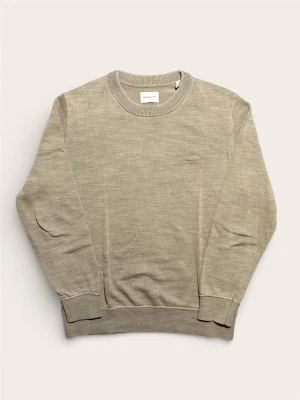 Beige stickad tröja från GANT - Säljer en stilren beige stickad tröja i storlek L från GANT med rund halsringning och diskret broderad logga på bröstet. Tröjan har ribbade muddar vid ärmslut och nederkant, perfekt för lager-på-lager under kyliga dagar.