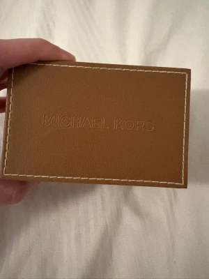 Silverfärgad Michael Kors klocka - Stilren klocka från Michael Kors i silverfärgat rostfritt stål. Klockan har en rund urtavla med flera små urtavlor och datumvisning. Kommer i original ask med beige insida. Perfekt accessoar för dig som gillar en clean och klassisk look.