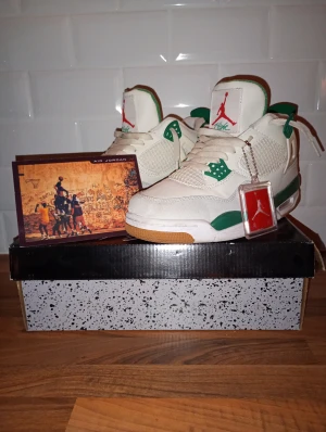 Air Jordan 4 retro sb nike - Nike Air Jordan 4 Retro sb, sneakers i vitt och grönt med röda detaljer. Skorna har klassisk snörning, meshpaneler och gummisula med röd Nike-logga undertill. Ikonisk Jumpman-logga på plösen och hängande tag. Perfekt för dig som vill sticka ut med ett par feta sb Jordan 4. Gratis marmor armband vid köp!