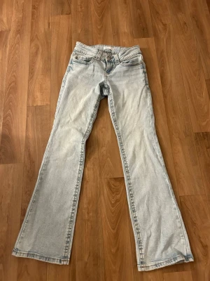 Ljusblå bootcut jeans från Gina tricot  - Säljer ett par ljusblå bootcut jeans från Gina. Jeansen är lågmidjade och med knapp vid fickorna där bak. Jag har bara använt dem 3 gånger så dem är som nya!