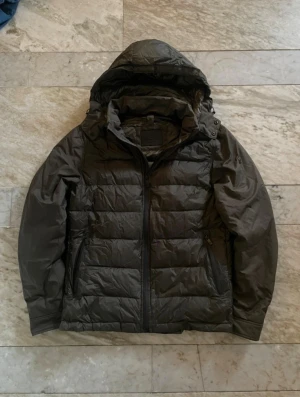 Mörkgrön dunjacka Massimo dutti - Massimo Dutti dunjacka, mörkgrön säljer en riktigt fin dunjacka från Massimo Dutti i storlek M men sitter som S. Den är i nyskick, knappt använd och kommer i en snygg mörkgrön färg. Jackan har normal passform, är vattentät, vindtät och fylld med dun som håller värmen riktigt bra. Huvan verkar dessutom vara avtagbar.  Säljer den bara för att den är lite för liten för mig – annars hade jag behållit den.  Pris: 899 kr 