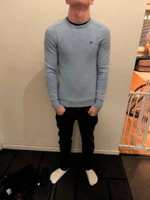 Ljusblå stickad tröja från Morris - Säljer en ljusblå stickad tröja från Morris i 100% merinoull. Tröjan har rund halsringning, lång ärm och en liten broderad logga på bröstet. Perfekt för dig som gillar en clean och stilren look.  Modellen är runt 168 cm och väger 55 kg. Det är bara att höra av sig vid frågor och funderingar 😀