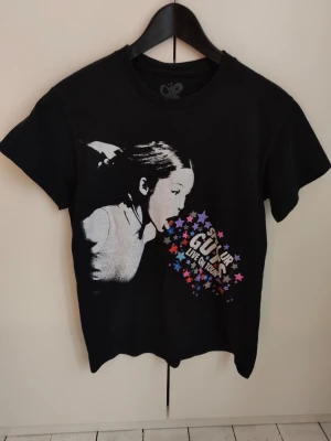 Olivia Rodrigo t-shirt GUTS tour - Svart t-shirt från Olivia Rodrigos GUTS tour 2024 med tryck av Olivia och färgglada stjärnor på framsidan samt turnéstäder på baksidan. Storlek S. 