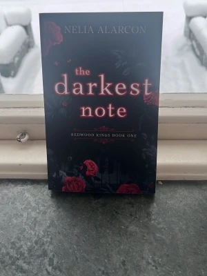 The Darkest Note - En mystisk och lockande bok med mörka toner och röda rosor på omslaget. Första delen i serien 'Redwood Kings'. Perfekt för dig som gillar spänning och dramatik i en modern miljö.