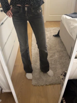 Grå bootcut jeans Gina Tricot - Säljer ett par grå jeans från Gina Tricot i storlek 152. Jeansen har bootcut-modell med normal passform och klassiska fem fickor. Materialet är jeans med snygga slitningar och kontrastsömmar. Perfekta för dig som gillar en avslappnad men ändå trendig look.