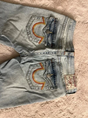 True religion jeans  - Säljer dessa ljusblå true religon jeans i storlek 26, de är lite slitna längst ner pga att de är för långa för mig. kan skicka fler bilder vid intresse 💕