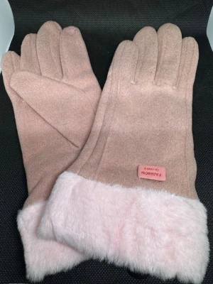Rosa vinterhandskar med fuskpäls - Snygga rosa vinterhandskar med mjuk fuskpäls vid handleden och en liten rosa etikett med texten 'FASHION GLOVES'. Handskarna har en enkel och stilren design, perfekta för kalla dagar.