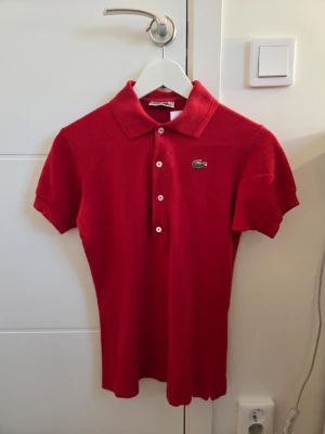 Lacoste Pikétröja  - Röd Pikétröja från Lacoste i mycket fint skick. Hel logga ✅️ Bekväm ✅️ Sällan använd ✅️ Vid köp av 2 eller fler produkter skickas ordrarna samma dag annars skickas ordern nästkommande dag. OPS! På min profil finns det 2 till pikétröjor från Lacoste alla tre tröjor kan köpas för 700:-. Styck pris: 250:-