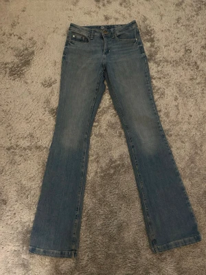 Blå bootcut jeans från Yessica (C&A) i storlek 34.  - Klassisk femficksdesign, normal passform och snyggt utsvängda ben. Liten skada i sömmen vid fickorna (syns på bild), men inget som märks mycket. I övrigt jättefina och i bra skick.det är storlek 34 men de kanske är tajta på mig kan visa bild men de passar mig som S