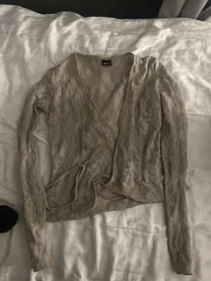Beige spetsomlottopp med knytband - Säljer denna fina spets toppen som man knyter på sidan. Det är en mint färgad topp och passar perfekt till sommaren!! Skriv privat för fler bilder eller frågor💕
