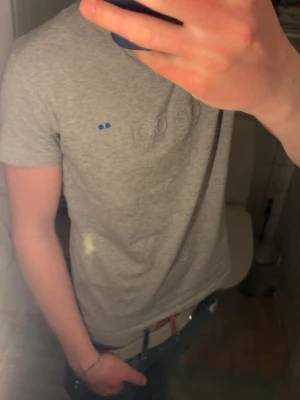 Grå Jacob Cohën T shirt S - En grå stilren t shirt ifrån Jacob Cohen som bokstavligt funkar till alla tillfällen! Den har ett grått tryck på bröstet med små blåa detaljer utöver tröjan! Tröjan är i storlek S och är true to size, den passar mig som 178-179 bra! Skriv för frågor och priset går att diskutera! 