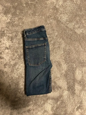 Mörkblåa slim jeans  - Säljer ett par mörkblåa slim jeans med raka ben och klassisk femficksdesign. Jeansen har normal passform och är tillverkade i slitstarkt denimtyg med snygg tvättad look. Perfekta till en avslappnad stil och funkar året runt.