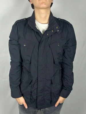 Woolrich Fieldjacket - Size: L Skick: 9/10, väldigt bra utan märkbara defekter. Retail pris: 4000kr (+). Modellen är 185cm och väger 78kg. Hör av dig vid frågor eller funderingar! 